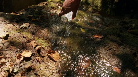 Man collects water from a source in a plastic bottle. Adventure in nature. Hi Stock Footage 296060524