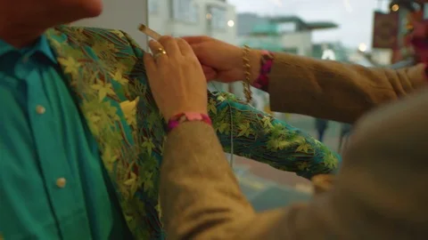 Man on colourful suit gets arm measured at the tailors Stockbeeldmateriaal 84483505