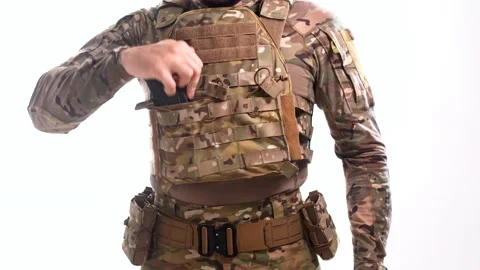 Man in combat camouflage inserts rifle magazines on the plate carrier Stock Footage 158012695