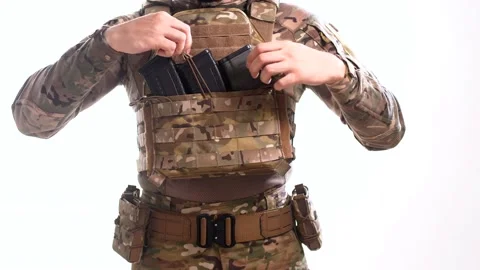 Man in combat camouflage removes empty rifle magazines on the plate carrier Stock Footage 158012726