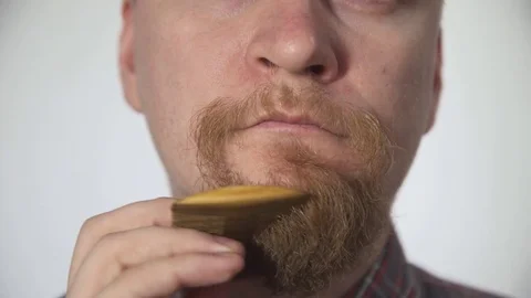 Man combing the beard comb on white background, shot close-up Stock Footage 74763212