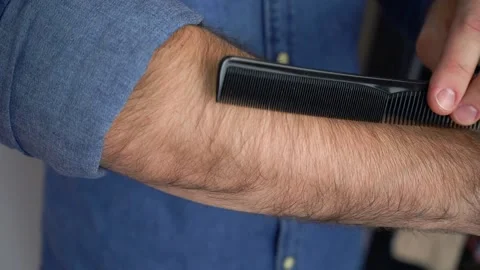 Man is combing the hair on the arm Stock Footage 147900742