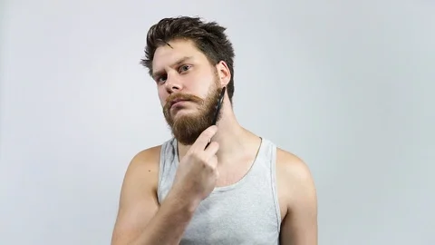 Man combing his beard. Hipster guy Brushing his ginger beard. Stock Footage 122442170
