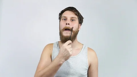 A man combing his mustache and beard comb. Guy brings beauty before the mirror. Stock Footage 122442565