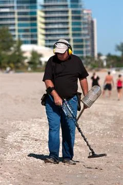 Man combs beach with metal detector Stock-Fotos