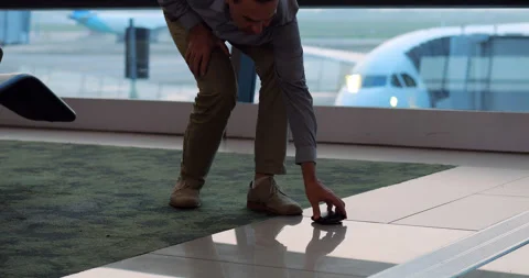 Man come back to pick up lost wallet from floor, airport terminal scene Stock Footage 306130427