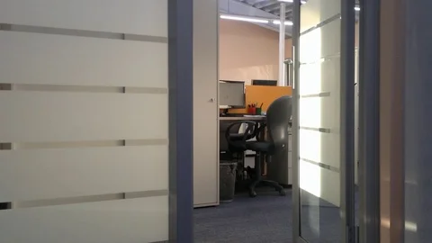 Man comes in and out through the office door with a bottle of water Stock Footage 69986426