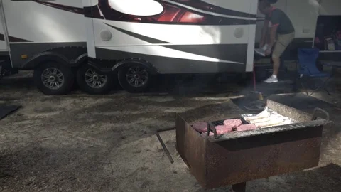 Man Comes out of 5th Wheel Camper to Cook Hamburgers Stock Footage