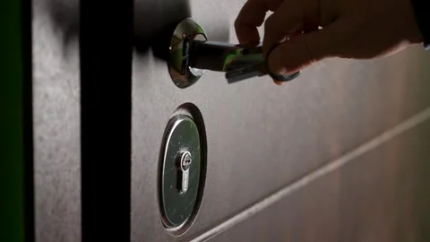 The man comes out of the door, inserting the key into the keyhole and locks.. Video stock 265081341