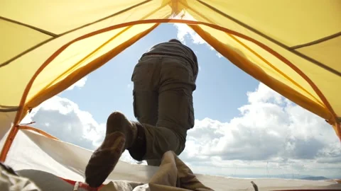 A man comes out of the tent, raises his hands to the sky, sunny weather Stock Footage 217395294