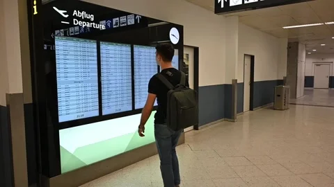 A man comes to the scoreboard to find out his flight Stock Footage 252126376