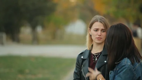 Man comes to two talking beautiful women in the autumn park Stock Footage 97181823
