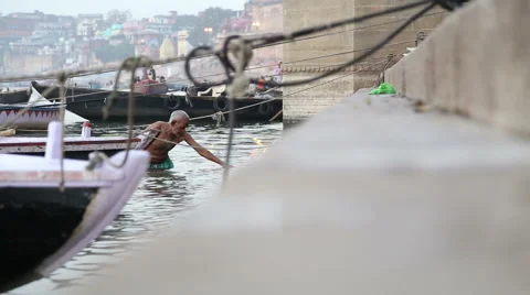 Man coming out of Ganges river and climbing up the stairs. Stock Footage 50410658