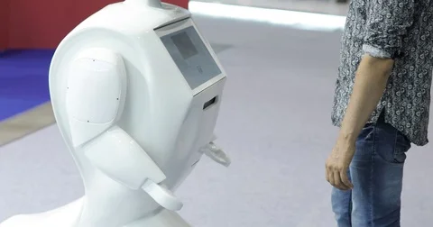 A man communicates with a robot, presses a plastic mechanical arm to the robot Stock Footage 76958258