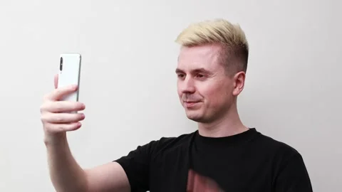 A man communicates on a smartphone. Takes a selfie. Records video Stock Footage 170606281