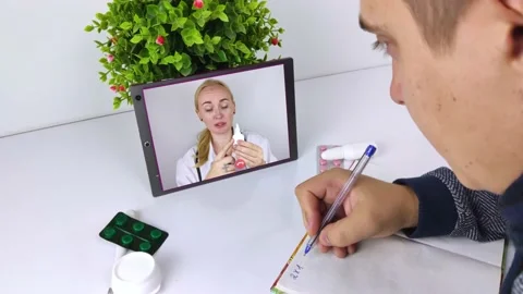 A man communicates via a tablet with a doctor via video link. Medical assistance Video stock 140264363