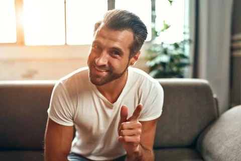A man communicates on a video call while sitting on the couch in the living r Foto stock