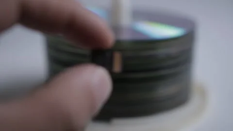 A man compare a 64Gb micro SD card to a stack of DVDs able to contain the same a Stock Footage 167430826
