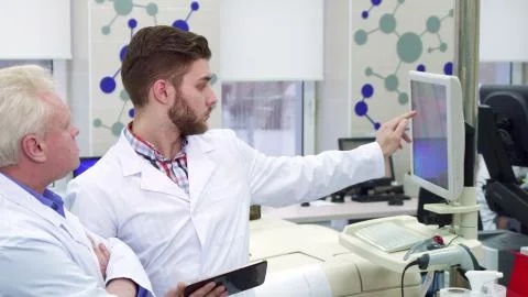 Man compares data on computer and tablet at the laboratory Foto stock