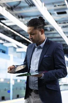 Man comparing silicon wafers inside semiconductor manufacturing plant Stockfoto's