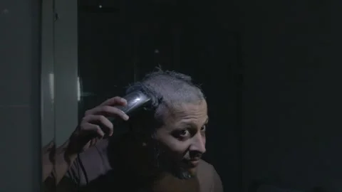 Man Completing DIY Buzz Cut with Trimmer Stock Footage 330584985