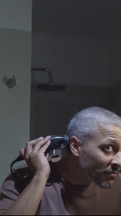 Man Completing DIY Buzz Cut with Trimmer Stock Footage 330585033