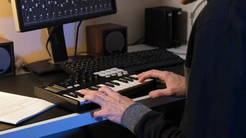 Man composing music at home with MIDI keyboard Stock-Footage 295876924