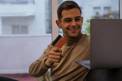 Man with computer and credit card buying online from home Stock-Fotos