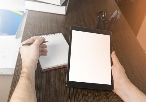 A man at a computer. Close-up of a hand, Mockup. White laptop and phone screen. Foto stock