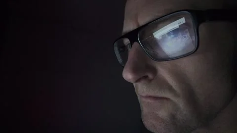 Man on computer in Dark room, screen reflection in glasses. Hull.UK. 1.2.2026 Stock Footage 327158674