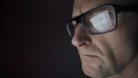 Man on computer in Dark room, screen reflection in glasses. Hull.UK. 2.1.2026 Stock Footage 327158678