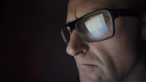 Man on computer in Dark room, screen reflection in glasses. Hull.UK. 1.3.2026 Stock Footage 327158679