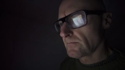 Man on computer in dark room, screen reflection in glasses. Hull.UK. 1.1.2026 Stock Footage 327158691