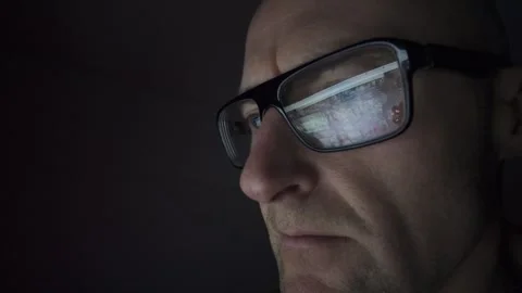 Man on computer in Dark room, screen reflection in glasses. Hull.UK. 1.3.2026 Stock Footage 327158721