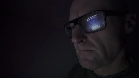 Man on computer in Dark room, screen reflection in glasses. Hull.UK. 1.1.2026 Stock Footage 327158722