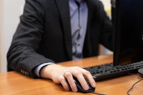 Man at the computer, hand on the mouse Stock Photos