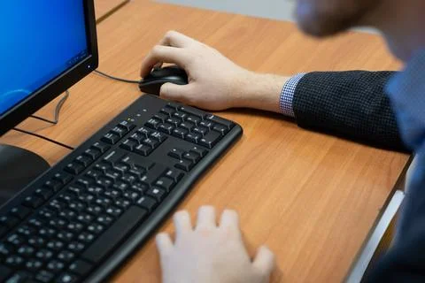 Man at the computer, hand on the mouse Stock Photos