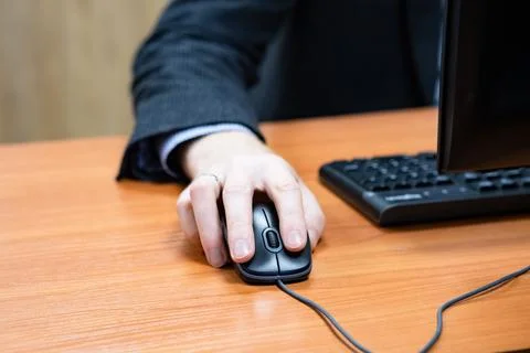 Man at the computer, hand on the mouse Stock Photos