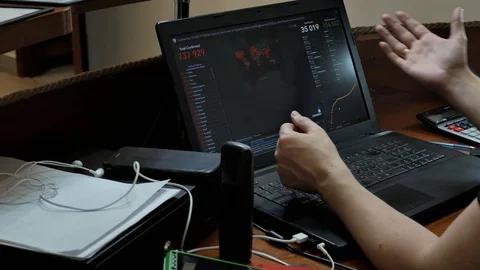 A man at a computer looks at the screen, watches the spread of the virus on a Stock Footage 128172648