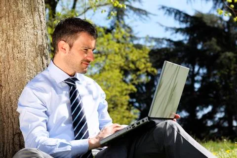 Man with computer in a park Stock Photos