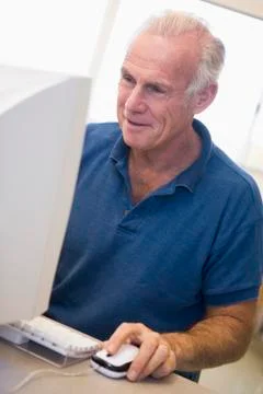 Man at computer smiling and looking at monitor (high key) Stock Photos