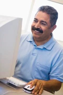 Man at computer smiling and looking at monitor (high key) Stock Photos