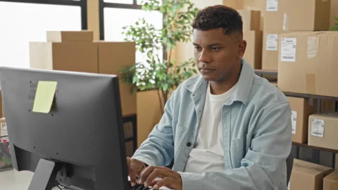 Man at computer surrounded by stacked boxes making a heart with hands near .. Stock Footage 347818490