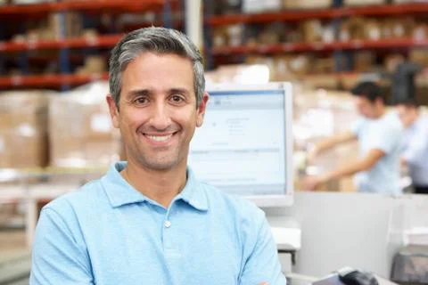 Man at computer terminal in distribution warehouse Foto stock