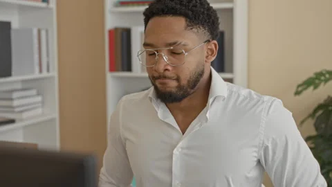 Man at computer wearing glasses and white shirt gestures with hand while st.. Stock Footage 337439936
