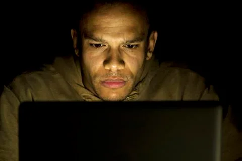 Man concentrating on his laptop late at night Stock Photos
