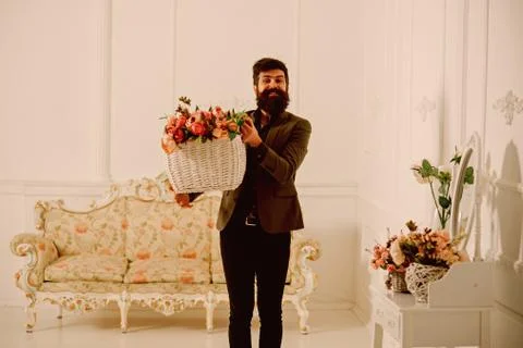 Man concept. Man with beard hold basket with roses. Man florist with flower Stock Photos