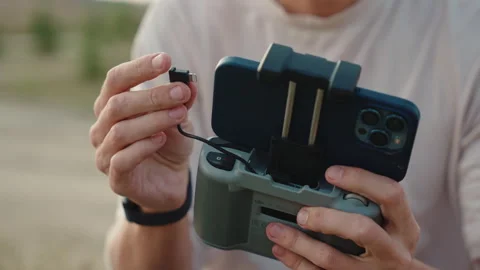 A man connect a phone to drone controller,close up,slow mo,sunset Stock Footage 252643073