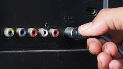 Man connecting an antenna cable to a television Stock Footage 344363423