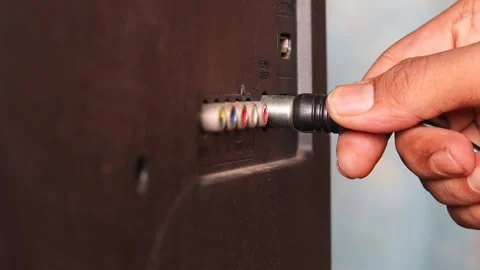 Man connecting an antenna cable to a television Stock Footage 344363468